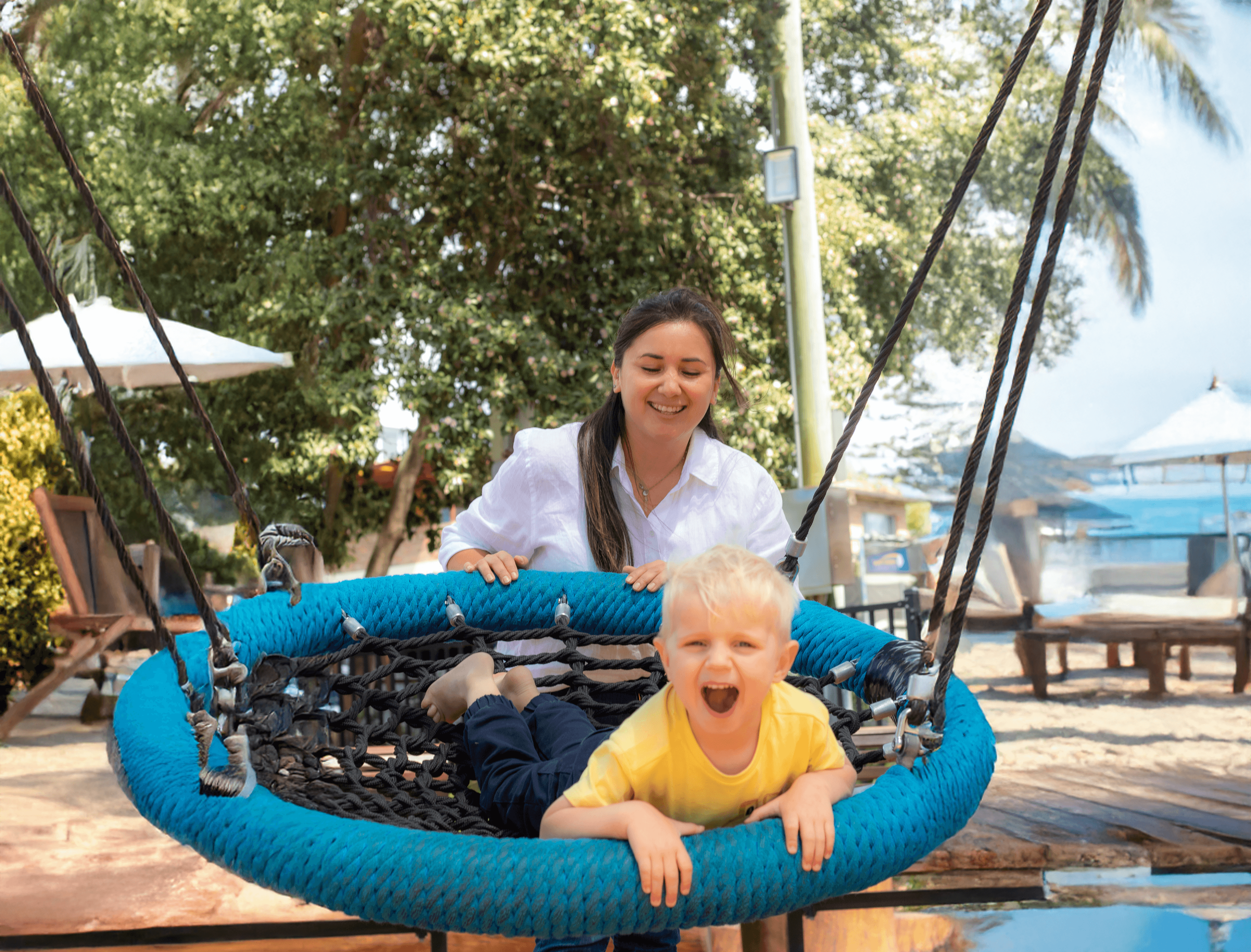 Carer and child on the swing in the park